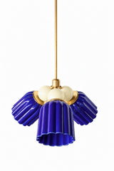 A small chandelier with deep, glossy cobalt fluted ceramic cone shades, paired with cream connector balls and brass hardware. The soft cream balls bring high contrast and a touch of restraint against the saturated blue, a versatile pairing for a traditional dining room or entry that wants real color without going fully bold in every element.