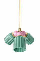 A small chandelier with glossy, glazed fluted ceramic cone shades in jade green, paired with soft blush pink connector balls and brass hardware. The pink and green pairing reads garden-party pretty without being childish, a strong fit for a nursery, a grandmillennial dining room, or any space layered with florals that wants its lighting to match.