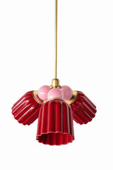 A small chandelier with deep, glossy jasper red fluted ceramic cone shades, paired with blush pink connector balls and brass hardware. The soft pink balls bring a gentler, more romantic contrast against the saturated red, a good pairing for a feminine traditional dining room or a grandmillennial-leaning space that wants bold color with a softer edge.