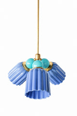 A blue and turquoise chandelier built for a coastal-leaning, color-loving house. The Marcella Small Chandelier is built from three fluted, scalloped ceramic shades in glossy sky blue, each attached at a round brass collar and flaring outward into a wavy, bell-shaped hem, arranged around a central cluster of poolside turquoise glass globe bulbs on a brass stem. The combination feels fresh and a little tropical rather than classic coastal. A great pick for a bathroom, breakfast nook, or sunroom that wants a t