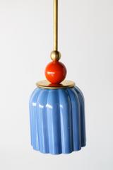 pastel light blue celadon-style glazed ribbed pendant light with poppy red-orange powdercoated ball and brass hardware.  Art deco inspired pendant light fixture. Made in New Orleans by Sazerac Stitches