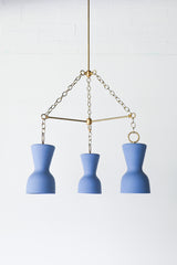 Blue porcelain and brass modern chandelier with ceramic shades and real brass chains and rods.  European inspired chandelier that has a slightly mid-century modern silhouette in a rich, shade of blue.  Perfect dining room chandelier.  Great ceramic & brass chandelier for minimalist, European inspired, mid century modern, eclectic, and Scandinavian style interiors.  Made in New Orleans by Sazerac Stitches.