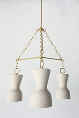 Cream porcelain and brass modern chandelier with ceramic shades and real brass chains and rods.  European inspired chandelier that has a slightly mid-century modern silhouette in a rich, shade of cream.  Perfect dining room chandelier.  Great ceramic & brass chandelier for minimalist, European inspired, mid century modern, eclectic, and Scandinavian style interiors.  Made in New Orleans by Sazerac Stitches.