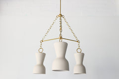 Cream porcelain and brass modern chandelier with ceramic shades and real brass chains and rods.  European inspired chandelier that has a slightly mid-century modern silhouette in a rich, shade of cream.  Perfect dining room chandelier.  Great ceramic & brass chandelier for minimalist, European inspired, mid century modern, eclectic, and Scandinavian style interiors.  Made in New Orleans by Sazerac Stitches.