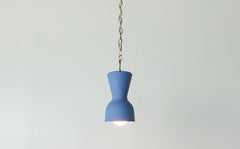 bright blue and brass chained ceramic pendant lighting fixture. Made in the USA hand-cast tinted porcelain pendant kitchen light with real raw brass chain.  Beautiful unglazed porcelain ceramic pendant ceiling light fixture. Matte blue porcelain chinoiserie inspired pendant light fixture.