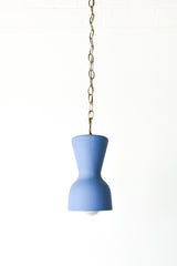 bright blue and brass chained ceramic pendant lighting fixture. Made in the USA hand-cast tinted porcelain pendant kitchen light with real raw brass chain.  Beautiful unglazed porcelain ceramic pendant ceiling light fixture. Matte blue porcelain chinoiserie inspired pendant light fixture.