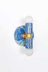 Mediterranean Blue, Cream & Gold Marbled Thalia wall sconces with a glossy, hand-marbled finish and warm brass center detail. Each piece is one-of-a-kind, with painterly swirls that feel coastal, eclectic, and unapologetically fun.