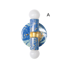 This version of the blue marbled Thalia sconce features a mix of deep blue, soft blue, white, and gold marbling with warm brass hardware at the center. The color combination gives it a coastal, water-inspired look, while the handmade marbled finish adds personality and makes it feel equally at home in eclectic or maximalist spaces.