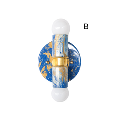 A hand-marbled blue Thalia sconce with swirling tones of cobalt blue, pale blue, white, and gold. The round backplate and cylindrical body are paired with brass detailing for a polished but playful look. This colorway feels bright, artistic, and slightly coastal, making it a great fit for bathrooms, hallways, or spaces with a colorful eclectic style.