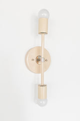 Angled side view of the Medium Thalia sconce in cream with chrome accents, showing the round backplate depth and the vertical double bulb layout, a polished modern wall sconce with a refined mid century modern feel photographed on a white background