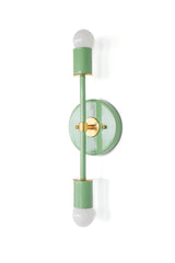 Side profile of the Medium Thalia wall sconce in vista green with brass backplate and details, a sleek vertical mid century modern fixture with two exposed globe bulbs, perfect for bathroom lighting, bedside sconces, and bold wallpaper moments.