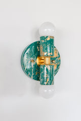 Thalia sconce in mermaid green, cream, and gold marbled finish, with round backplate and brass center detail, fitted with two globe bulbs. Compact statement wall sconce or flush mount ceiling light for bathroom vanity lighting, powder room decor, coastal contemporary bedrooms, or pastel and jewel-tone interiors.