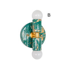 Angled view of mermaid green, cream, and gold marbled Thalia sconce option B showing the round backplate depth, brass center band, and two globe bulbs. Small-space statement lighting that works as a wall sconce or flush mount, perfect for a feminine bathroom, powder room, coastal modern bedroom, or maximalist entry.