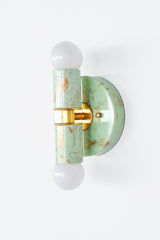 Small Thalia Sconces in a soft mint and cream hand-marbled finish with gold accents, photographed together to show the natural variation in each piece. The petite wall sconce has a playful but polished look, making it a lovely option for bathroom vanity lighting, small powder rooms, kids bathrooms, nursery bathrooms, or colorful guest baths. The marbled green finish pairs easily with brass fixtures, pastel tile, chinoiserie wallpaper, and grandmillennial decor.