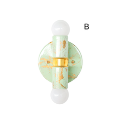 A close product photo of the Small Thalia Sconce in a mint, cream, and gold hand-marbled finish, shown in three unique variations to highlight the handmade patterning. The small two-bulb wall light has a soft, decorative look that works well in powder rooms, kids bathrooms, colorful hallways, and vanity spaces. Its pale green marbling, warm gold hardware, and compact shape make it a sweet fit for chinoiserie decor, grandmillennial style, and muted maximalist interiors.