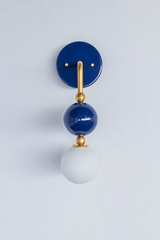 A deep navy wall sconce for a bathroom, powder room, or bedroom that leads with classic, confident color. The Ida sconce stacks a glossy navy powder-coated sphere over a frosted glass globe, joined by warm brass hardware and a round navy backplate. Timeless and grounded, navy-and-brass is the not-boring safe choice for coastal traditional, grandmillennial, Chinoiserie, and Southern interiors.