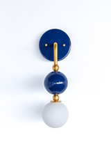 Timeless, colorful vanity lighting that gives a bathroom, powder room, or coastal bedroom a confident point of view. Seen in profile, the Ida sconce shows off its curved brass arm reaching from a glossy deep-navy backplate down to a stacked navy sphere and frosted glass globe. The side view highlights the brass ball detailing and how far the fixture projects off the wall. A classic navy-and-brass pairing for coastal traditional, grandmillennial, and colorful traditional interiors.