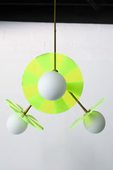 Close-up photo: Intricately etched acrylic disc in neon green adds a playful touch to the Circus Chandelier