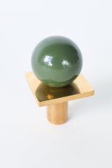 Glossy olive green and brass square gumball drawer knob with a midcentury modern look. Ideal for colorful cabinet hardware, kids’ room dressers, vintage furniture makeovers, or playful kitchen and bathroom updates. Adds bold color, charm, and custom personality to any space.