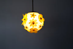 Illuminated yellow blossom acrylic globe pendant, cozy ambient light with dimensional petals and warm hardware, modern playful statement for design-forward homes, truly one of a kind and studio crafted.