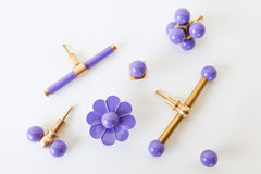 Glossy pastel purple and brass collection of drawer pulls, cabinet hardware collection made by sazerac stitches. Colorful, playful and bright furniture knobs and pulls perfect for jewelbox bathrooms, colorful kitchens, playful spaces for kids, and more.