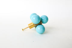 Oversized Ball-Cube Knob in Poolside, featuring five glossy, powder-coated spheres on a brass cube base. This 2.75-inch-wide, handmade drawer pull is available in 30 curated colors, making it a stylish and customizable addition to cabinets, dressers, or drawers for a bold, modern touch.