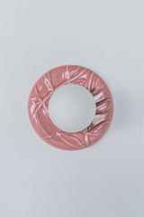 Front view of pastel pink Leafy Sconce lit up, frosted globe casts warm ambient light and highlights the sculptural leaf pattern, feminine statement sconce.