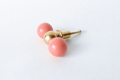Peach and brass double gumball drawer pull, straight-on view. Two glossy peach balls flank a brass center ball, a versatile colorful hardware pick for furniture makeovers, bathroom vanities, built-in cabinets, kitchens, kids' rooms, offices, or any space that needs a little personality.