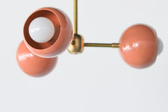 Peach & Brass Mid Century Modern style 3-light flushmount ceiling light fixture.  Features brass hardware with powdercoated glossy peach shades.  Adds color and unique style to any ceiling.  Great ceiling light fixture for low ceilings, kids rooms, bathrooms, peach decor, and more.