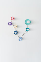 Colorful Pisces zodiac wall sconce with chrome hardware and glossy powder coated steel discs in blush pink, orchid purple, cream, denim blue, celestial teal, and poolside aqua, styled as a star sign constellation light fixture with white globe bulbs. Modern sculptural wall lighting for a bathroom vanity, pretty powder room, maximalist bathroom, coastal eclectic home, kids room or teen room decor, mid century modern inspired statement sconce, playful colorful modern wall lamp for an artistic home.