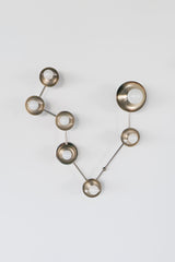 Pisces zodiac wall sconce in polished chrome with a branching constellation silhouette, featuring multiple small white globe bulbs on reflective metal disc backplates; modern sculptural wall light for a statement powder room, maximalist bathroom vanity lighting, eclectic entryway or hallway, mid century modern inspired star sign fixture with crisp geometric arms and gallery style presence.