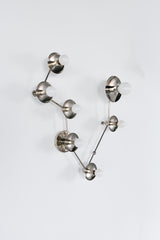 Angled side view of a Pisces star sign sconce in chrome, showing the dimensional branching arms and round metal disc details behind each white globe bulb; contemporary constellation wall fixture that reads like functional wall art, ideal for eclectic home decor, mid century modern lighting fans, bold bathroom lighting over a mirror, moody modern bedroom accent light, or a unique zodiac inspired statement piece.