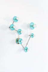 Angled view of Pisces constellation light fixture in Poolside blue and chrome, with sculptural branching arms, powder-coated steel disc backplates, and round globe bulbs; statement wall lighting with mid century modern vibe for an artful bathroom sconce over a mirror, fun powder room lighting, coastal color pop decor, and bold maximalist style.