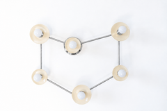 A Capricorn constellation wall sconce with six globe bulbs set in cream disc shades, each one a star, linked by thin polished nickel rods that trace the sea goat sign. The cool silver reads like starlight against a pale wall. Hang it over a bed, a reading chair, or a crib in a Capricorn nursery. Cream and nickel suit celestial bedroom ideas, star sign decor, and soft gray or white modern rooms, and it makes a thoughtful birthday gift for the Capricorn in your life.