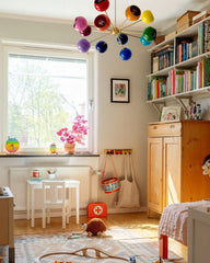 Prism Chandelier by Sazerac Stitches installed in a modern children’s playroom with natural light, wooden furniture, and colorful toys. This bold 12-color rainbow sputnik chandelier with brass arms is ideal for nurseries, kids’ rooms, dopamine decor, eclectic interiors, and mid-century modern homes that embrace fun, creative, and colorful lighting.