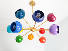 Rainbow sputnik chandelier with glossy multicolor globe shades and warm brass arms, modern mid century ceiling light with red, pink, orange, yellow, green, teal, blue, and purple orbs, playful maximalist statement lighting for a kids bedroom, nursery, playroom, or colorful dining room, contemporary atomic starburst chandelier