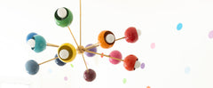 Prism Chandelier in a bright kids playroom with colorful polka dot walls, blue play kitchen, plush seating, and rainbow toys. Mid-century modern rainbow sputnik ceiling light adds fun, eclectic dopamine décor perfect for nurseries and children’s rooms.