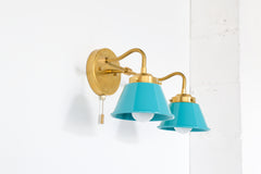 Side view of Double Kelly wall sconce in brass with teal shades and a pull chain switch for easy operation.