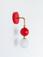 A glossy cherry-red wall sconce for a bathroom, powder room, or entryway that leads with confidence and color. The Ida sconce stacks a saturated red powder-coated sphere over a frosted glass globe, joined by warm brass hardware and a round red backplate. Sexy, playful, and unapologetically bold, it's a standout for eclectic, maximalist, and colorful traditional homes that reject the safe answer.