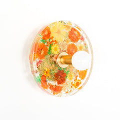 orange floral wall sconce with brass hardware. uses real dried flowers and pressed leaves.