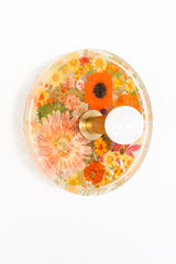 Modern two light wall sconce with brass hardware and orange flowers. Features resin-encapsulated orange flowers with greenery, ferns, and leaves.  Adds a real-like nature theme to any interior design project.  Called the Botanico Sconce by Sazerac Stitches. Features orange flowers with greenery