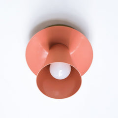 Peach mid century sculptural wall sconce with a peach powdercoated finish and modern design