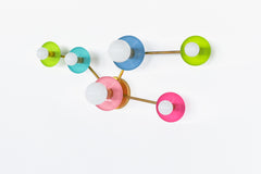 Bright color Taurus wall lamp with pastel chartreuse and pink, poolside teal, and celestial blue discs that read like modern wall art when off and a glowing constellation when on. Great for a pretty powder room, feminine bathroom, maximalist decor, or bold modern interior design.