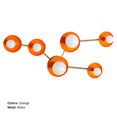 Studio product photo of the Sazerac Stitches Taurus sconce, a star-map inspired sculptural wall sconce with six round powder-coated steel discs and white globe bulbs. This version features a bold orange colorway paired with warm brass arms and a brass backplate, photographed on a bright white background to highlight the saturated finish and crisp silhouette. A modern statement wall light that reads like illuminated art, perfect for designers searching orange brass wall sconce, modern brass bathroom lighting