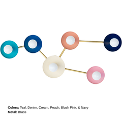 Multicolor Taurus sconce with brass hardware and white globe bulbs, designed to mimic the stars of the Taurus constellation. A playful modern wall light in aqua, blue, coral, cream, pink, and deep blue.