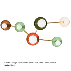 Taurus constellation wall sconce in earthy colors with brass arms and white globe bulbs, handmade by Sazerac Stitches in New Orleans. This sculptural celestial wall light features warm brown, mint green, olive, cream, and terracotta tones.