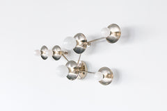 Modern chrome wall sconce inspired by the Taurus constellation, featuring mixed-size star discs and a crisp, graphic layout. Polished chrome finish with globe bulbs for a clean contemporary glow. Handmade to order by Sazerac Stitches in New Orleans. Ideal statement sconce for foyer lighting, stair landings, or gallery-style hallways.