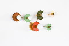 Sazerac Stitches Taurus sconce in earthy colors and brass, made to order in New Orleans. This celestial wall light mixes soft green, warm brown, cream, and coral hues in a constellation design that works beautifully as functional wall art.