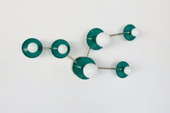 Studio product photo of the Taurus constellation wall sconce by Sazerac Stitches in Mermaid Green powder-coated steel discs paired with polished chrome arms. A constellation-inspired arrangement of circular star discs and frosted globe bulbs includes two larger discs with larger globes and three smaller discs with smaller globes, forming a crisp modern star pattern on a clean white background. Great inspo for searches like green and chrome wall sconce, teal bathroom vanity lighting, modern constellation sco