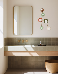 Handmade Taurus sconce designed to mimic the Taurus star constellation, featuring earth-tone discs in brown, olive, sage green, terracotta, and cream with brass hardware. A statement bathroom wall light for a spa-like, natural, design-forward space.